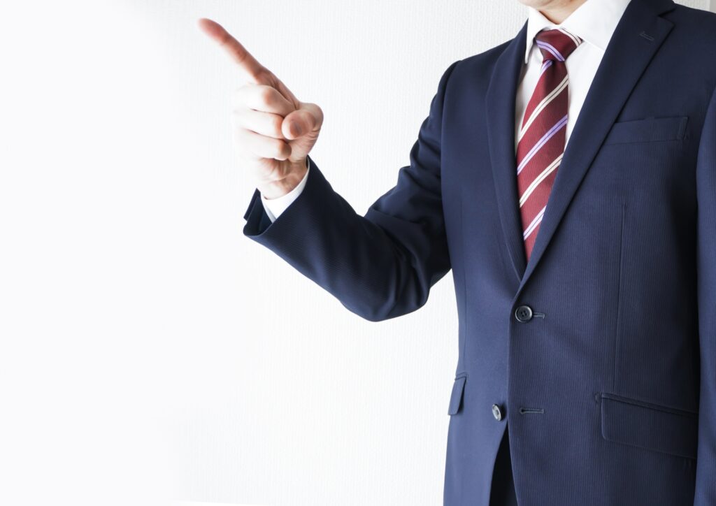 スーツを着た男性が指差して教えている画像