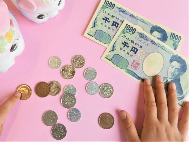 お小遣い、副業のイメージ。お金(紙幣、小銭)と貯金箱
