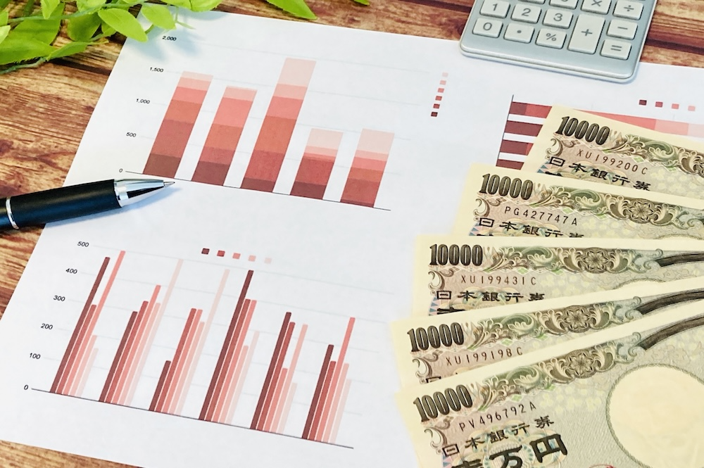 統計データとお金の置かれた画像