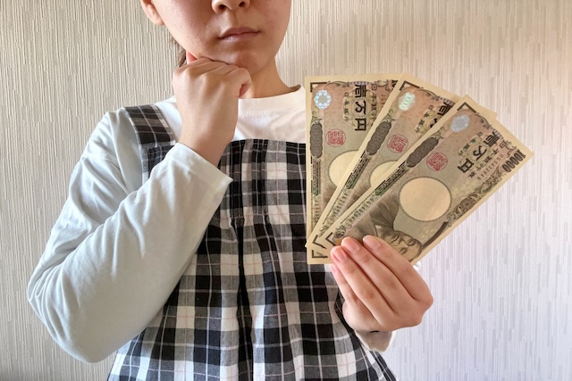 お札を持ち悩む女性の様子