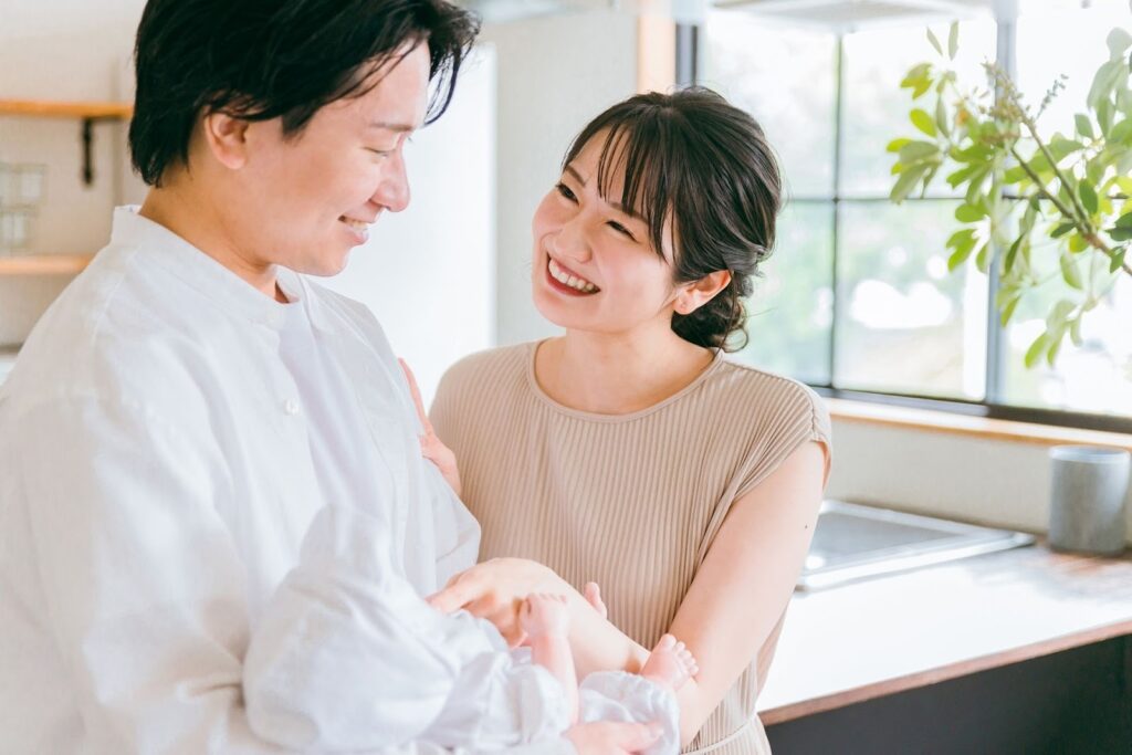 赤ちゃんを抱えて微笑む夫婦