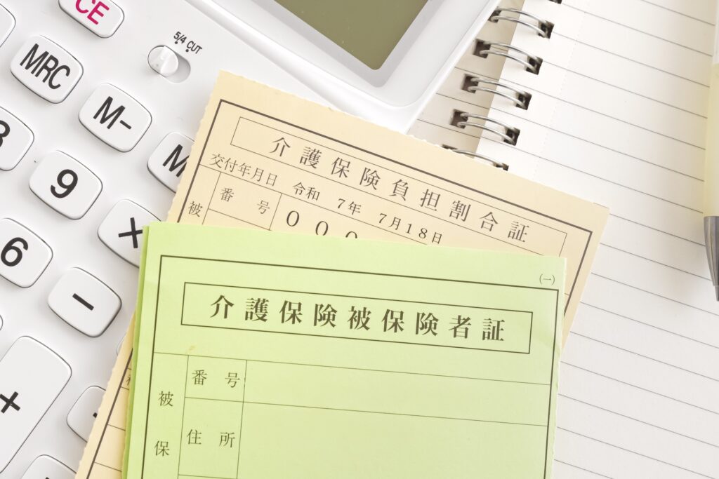 介護保険被保険者証と電卓、ノート