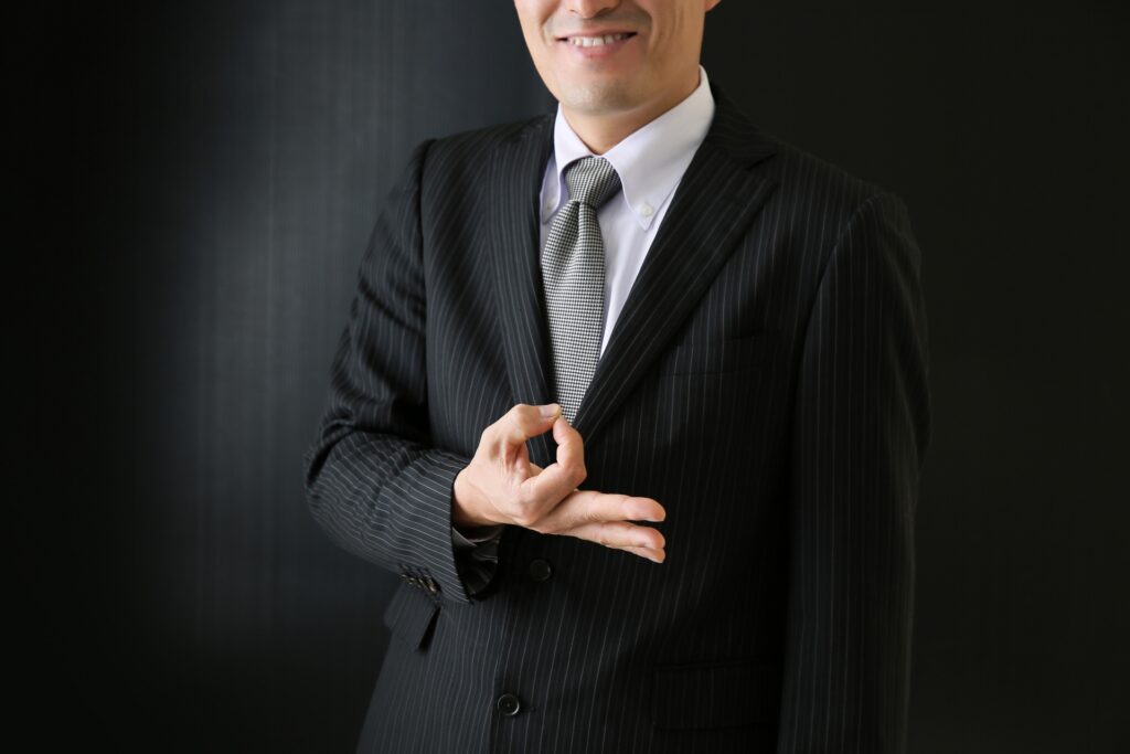 お金のポーズをするサラリーマン