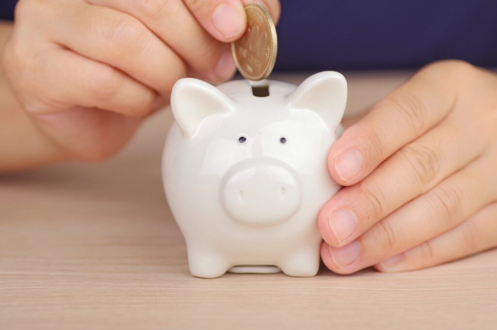 貯金箱にお金を入れる子供